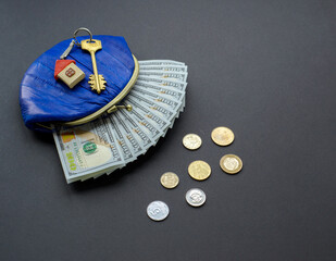 Real estate concept. wallet with paper money and a house keys on table, and coins