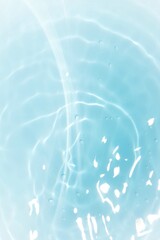 Water surface. Bluewater waves on the surface ripples blurred. Defocus blurred transparent blue colored clear calm water surface texture with splash and bubbles. Water waves with shining pattern.