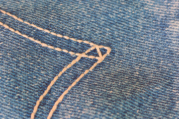Close-up texture of denim fabric with visible stitching and threads
