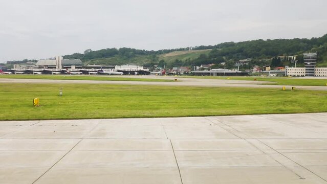 Landing of aircraft in airport at summer, view from window of plane