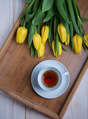 White coffee mug with yellow tulips. Space for text or design.