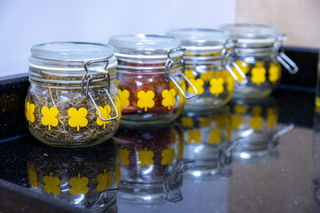kitchen spices and ingredients jars on black and white background with reflection