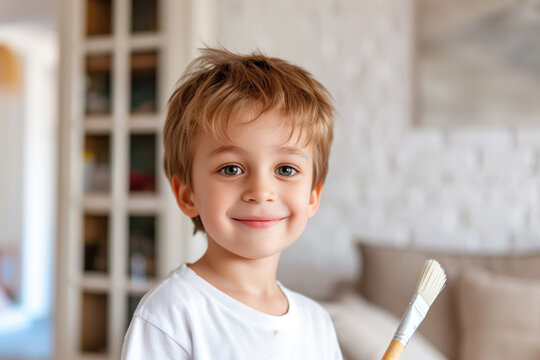 Happy young boy confidently holding a painting brush during home renovation