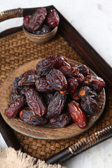 Ripe large dates on platter. Sweet snack for the Ramadan holiday. Fruits of date palm. Vertical photo.