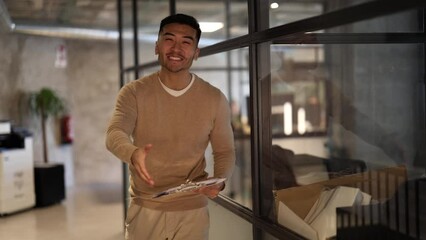 Human resources worker of Asian ethnicity warmly greets new colleague ready to shake hands welcoming