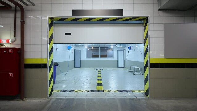Entrance gate lifted up and open empty car wash room