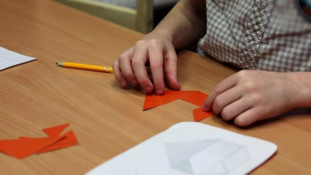 Boy collects geometric puzzle using schema on table in children club