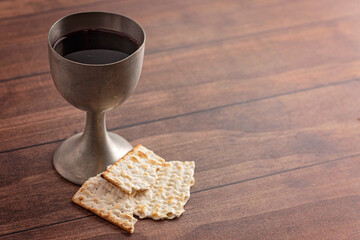Holy Communion in a Pewter Goblet with an Antique Bible on a Wooden Table