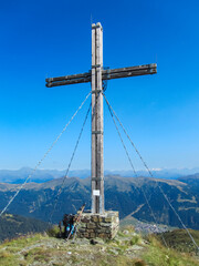 Panoramic view of summit cross in majestic Carnic Alps, Carinthia, border Italy Austria. Scenic...