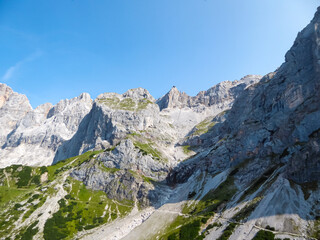 Fototapeta na wymiar Panoramic view of majestic mountain peak Hoher Dachstein in Northern Limestone Alps, Styria, Austria. Scenic hiking trail in wilderness Austrian Alps. Peace of mind, calmness. Wanderlust in nature