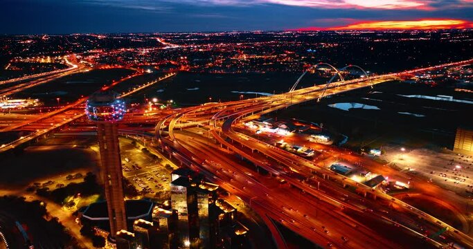 Well-lit highways and speedways in the downtown of Dallas, Texas, USA. Panorama of the city at night from drone footage.