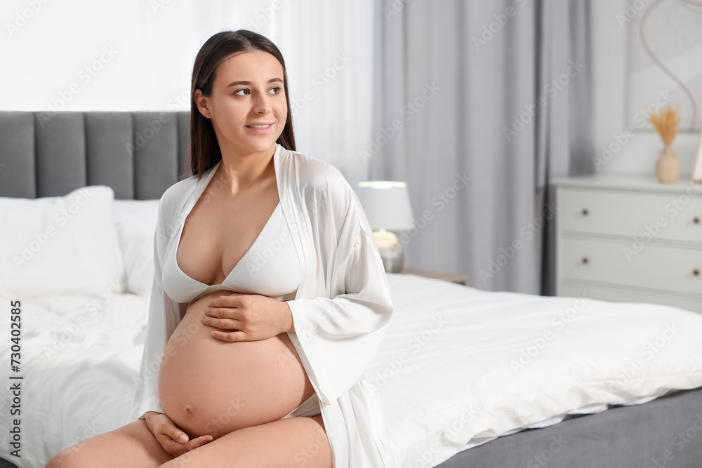 Canvas Prints Beautiful pregnant woman in stylish comfortable underwear and robe on bed at home, space for text