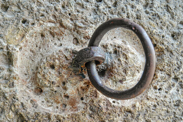 Old rusty door handle on a stone wall, closeup of photo