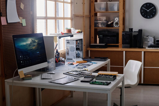 Workplace of electronic repairman in workshop with tools and disassembled computer elements on table