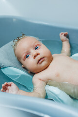 Baby's first baths. Caring for a newborn baby. Bathing a baby in a bathtub. A newborn baby is bathing in the water.