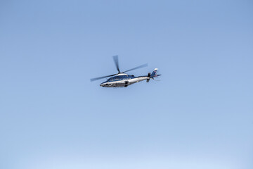 Fototapeta na wymiar Police helicopter flying in air with cloudy sky. 