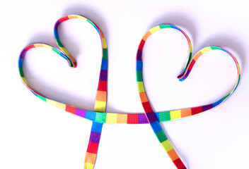 two hearts in rainbow colors on a white background. LGBT rainbow ribbon pride ribbon symbol. Same-sex love and wedding concept. month or happy singles day. Gay pride