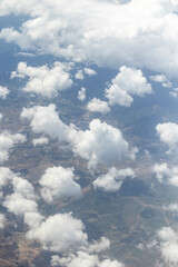 View from the airplane window, clouds, land, and sky