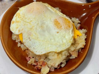 A breakfast skilled with two fried eggs and hash browns