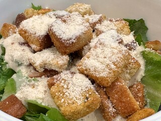 Macro of a Caesar's salad with croutons and parmesan cheese