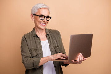 Photo of smiling amazon seller specialist in ecommerce mature business woman looking laptop her...