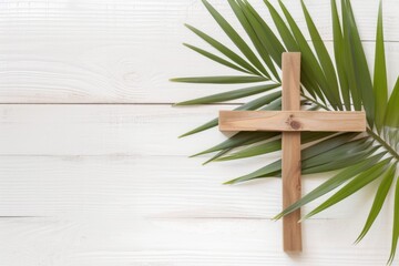 A wooden cross with a palm leaf on a white wooden background Palm Sunday, wooden christian cross...