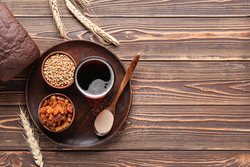 Glass of tasty kvass and ingredients on wooden background