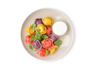 Plate of boiled colorful dumplings with basil and sour cream on white background