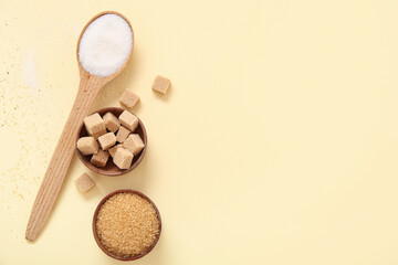 Bowls and spoon with different types of sugar on beige background