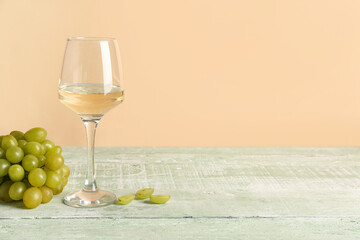 Glass of tasty wine and grape on green wooden table