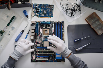 Unrecognizable electronic repairman holding CPU before placing it into PC mainboard socket