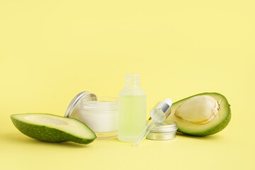 Composition with cosmetic products and ripe avocado on color background
