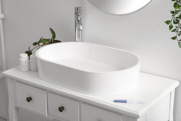 Sink with pregnancy test and pill bottles in bathroom