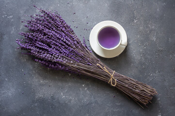 Cup of lavender tea with dried lavender flowers on rustic table, herbal relaxing tea. Lavendula oleum