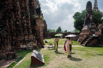 thai women walking through the temple - 730432786