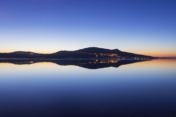 The reflection of the Pálava Mountains on a calm water surface at a wonderful sunset. The calm...