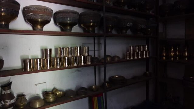 Copper-brass appliances are displayed in wooden cupboards. 