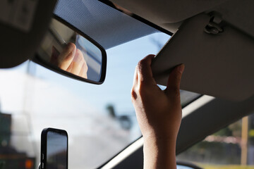 Hand holding car sun visor - obrazy, fototapety, plakaty