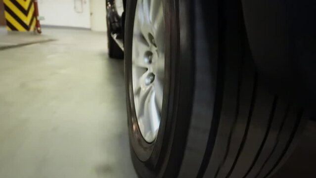 Tyre of circling rear wheel of car which rides by underground garage