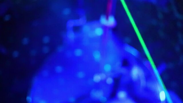 Woman in black dress performs pole dance in strip club, soft focus