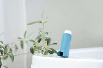 Asthma inhaler on bathtub in bathroom, closeup