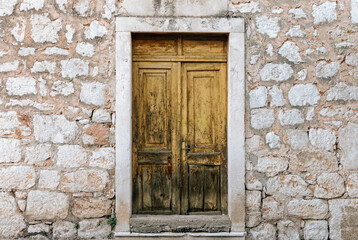 Rustic wooden door on old stone house