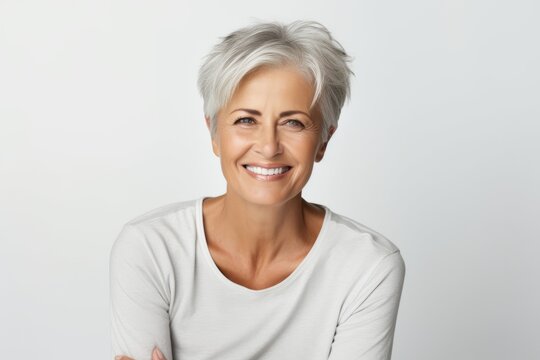 Portrait of happy senior woman with grey hair smiling at camera.