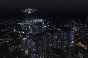 Alien spaceship flying over city at night. UFO, extraterrestrial visitors