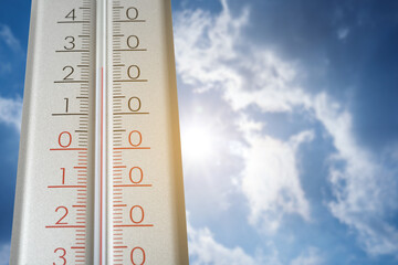 Thermometer and blue sky with clouds on sunny day, low angle view. Space for text