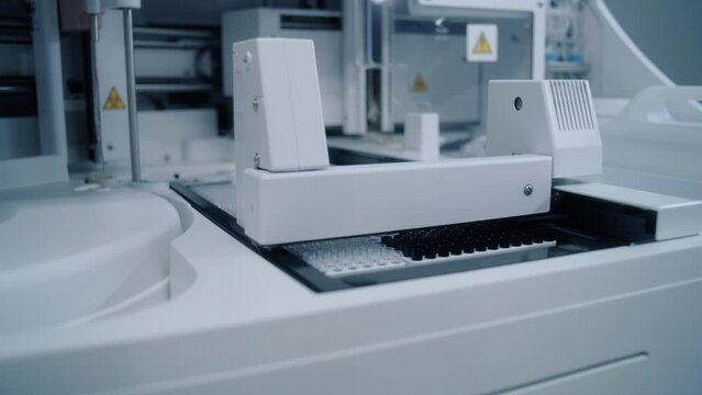 Medical automatic machine analyzes blood samples in test tubes. Advanced research lab with modern equipment. Development of drugs or vaccine in professional biotechnology or pharmaceutical laboratory.