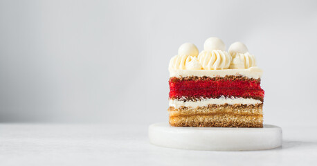 A slice of vanilla red velvet cake with buttercream filling, thin layers of vanilla and red velvet...