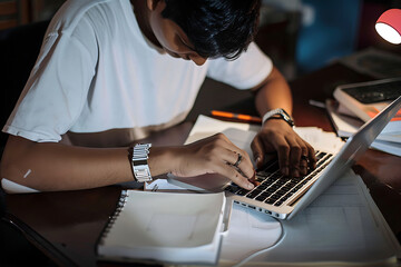 Una persona trabajando en su escritorio  con su laptop  y libros y un  café  - obrazy, fototapety, plakaty