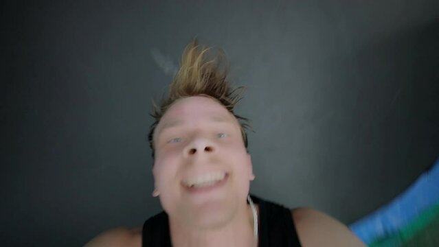 Face of young man which jumps on outdoor trampoline. Slow motion