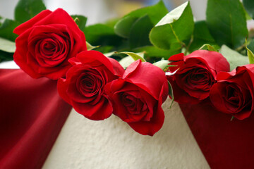 Close-up of red long stemmed roses resting on an American flag commemorating Memorial Day in the United States of America.